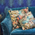 Blue sofa with patterned pillows and peacock wall paper 